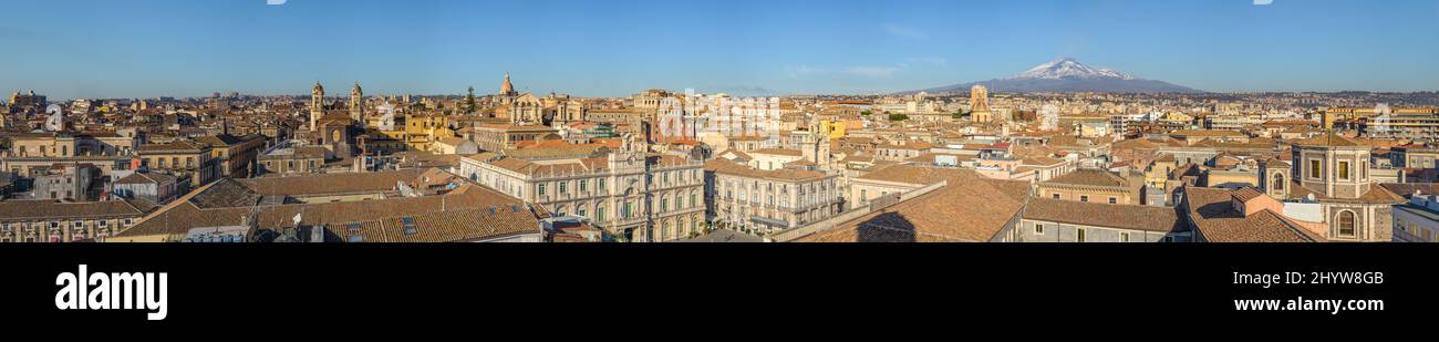 Bannerpanorama des Stadtzentrums von Catania von der Kirchentrasse Saint Agatha, mit historischen Gebäuden, Kirchen und Universität, und Vulkan Ätna erup Stockfoto