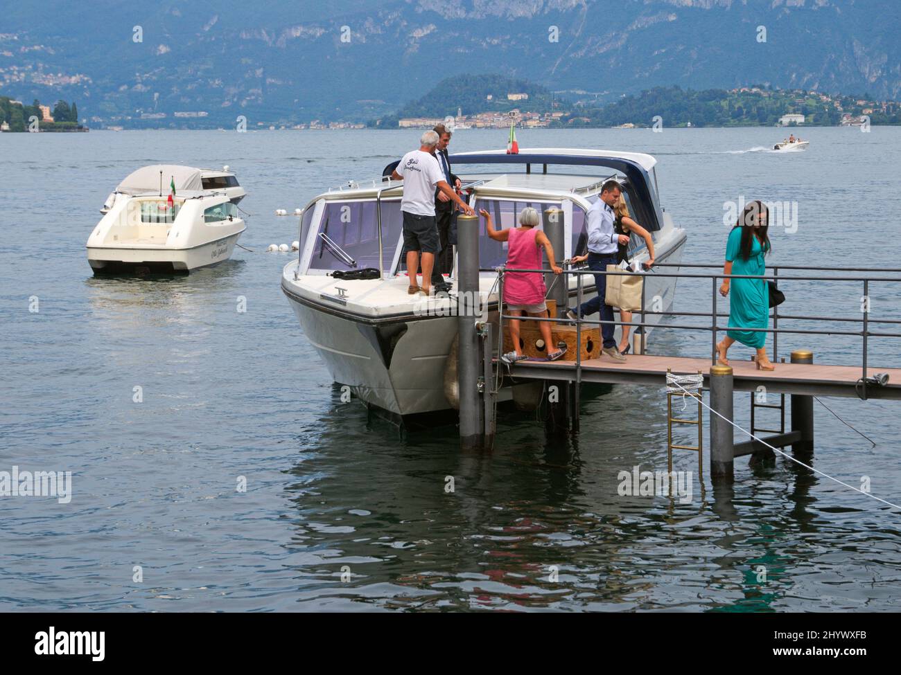 Menschen, die aus einem Wassertaxi am Pier von Lenno, Comer See, Italien, steigen Stockfoto