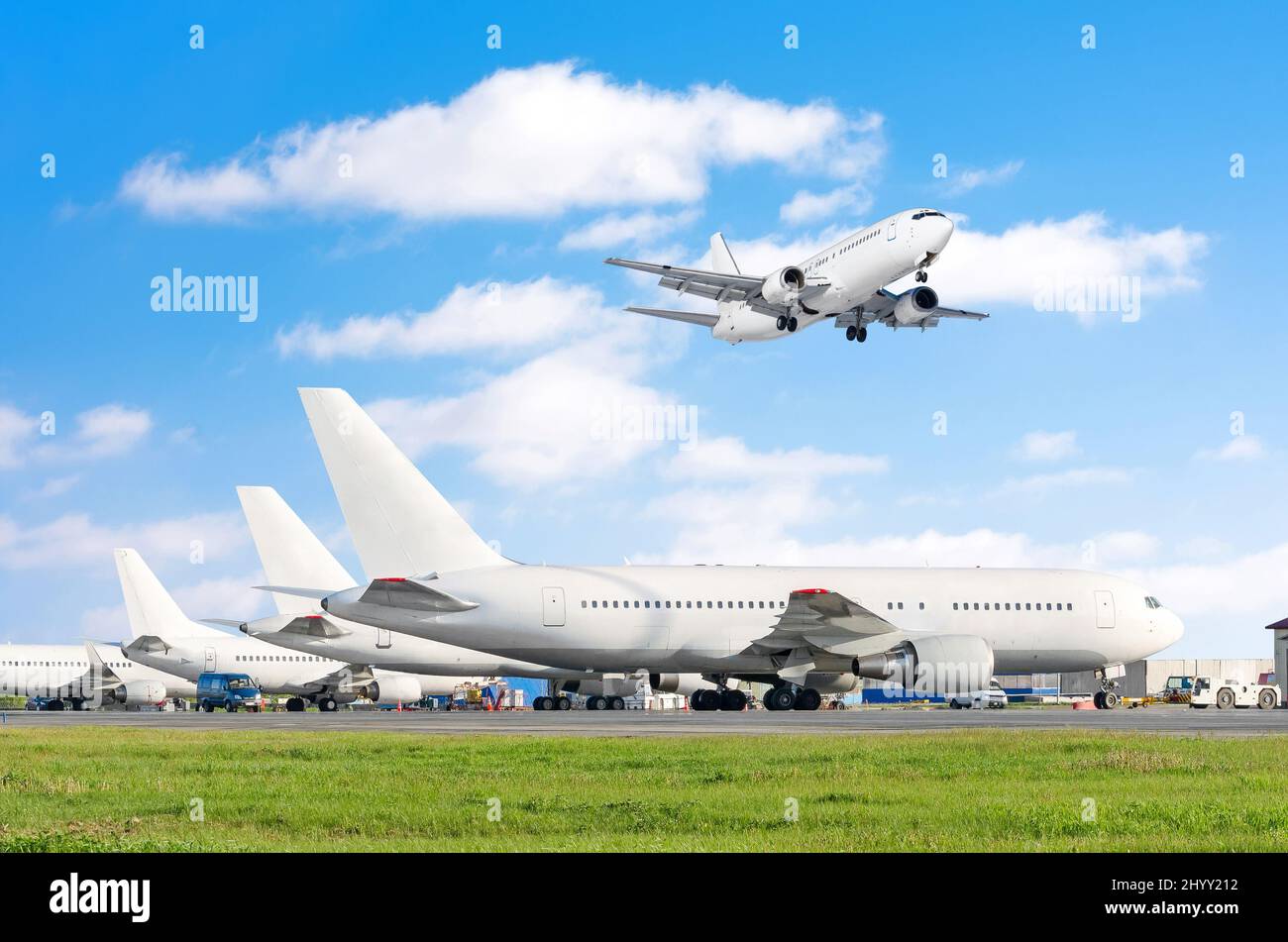 Reihe von Passagierflugzeugen, Flugzeug geparkt auf Service vor dem Abflug. Am Flughafen, andere Flugzeug schieben zurück Schlepptau. Eine Landung auf der Landebahn in der sk Stockfoto