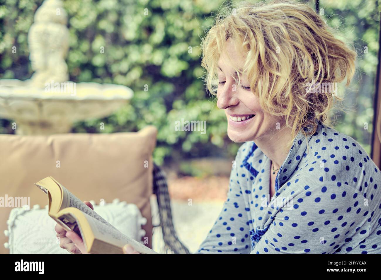 Porträt einer jungen reifen kaukasischen Frau drinnen zu Hause, die ein Buch liest. Quarantänekonzept. Stockfoto