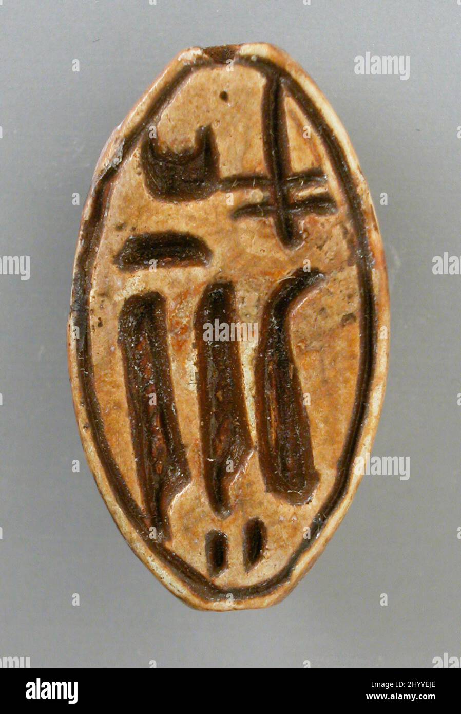 Lentoid mit dem Namen der Königin Tiy. Ägypten, Neues Königreich, 18. Dynastie, regiert von Amenhotep III und Echnaton (1410–1355 v. Chr.). Skulptur. Steatit mit moderner brauner Farbe Stockfoto