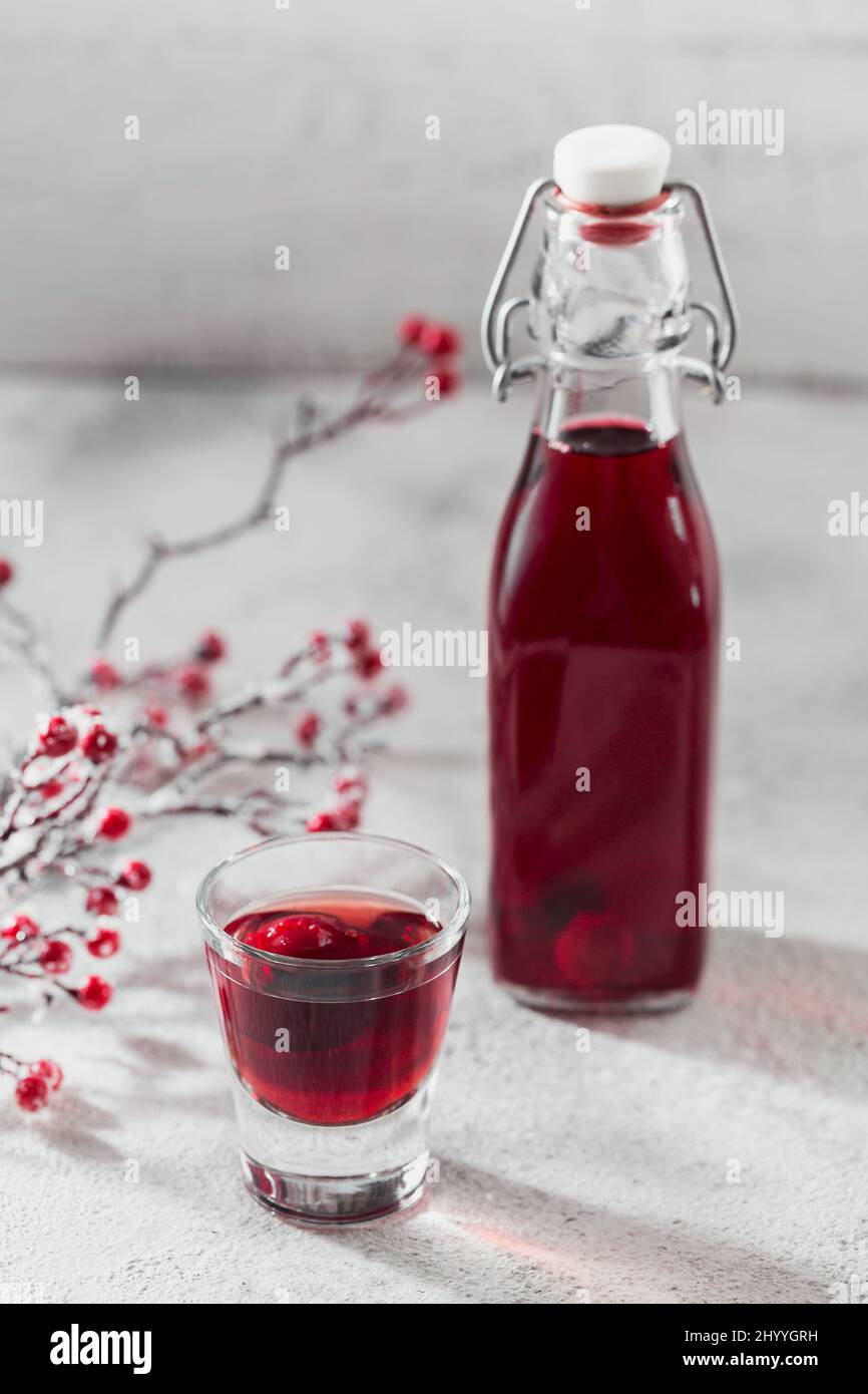 Hausgemachter infundierten Wodka, Tinktur oder Likör aus roter Kirsche auf weißem Hintergrund. Berry alkoholische Getränke Konzept. Stockfoto