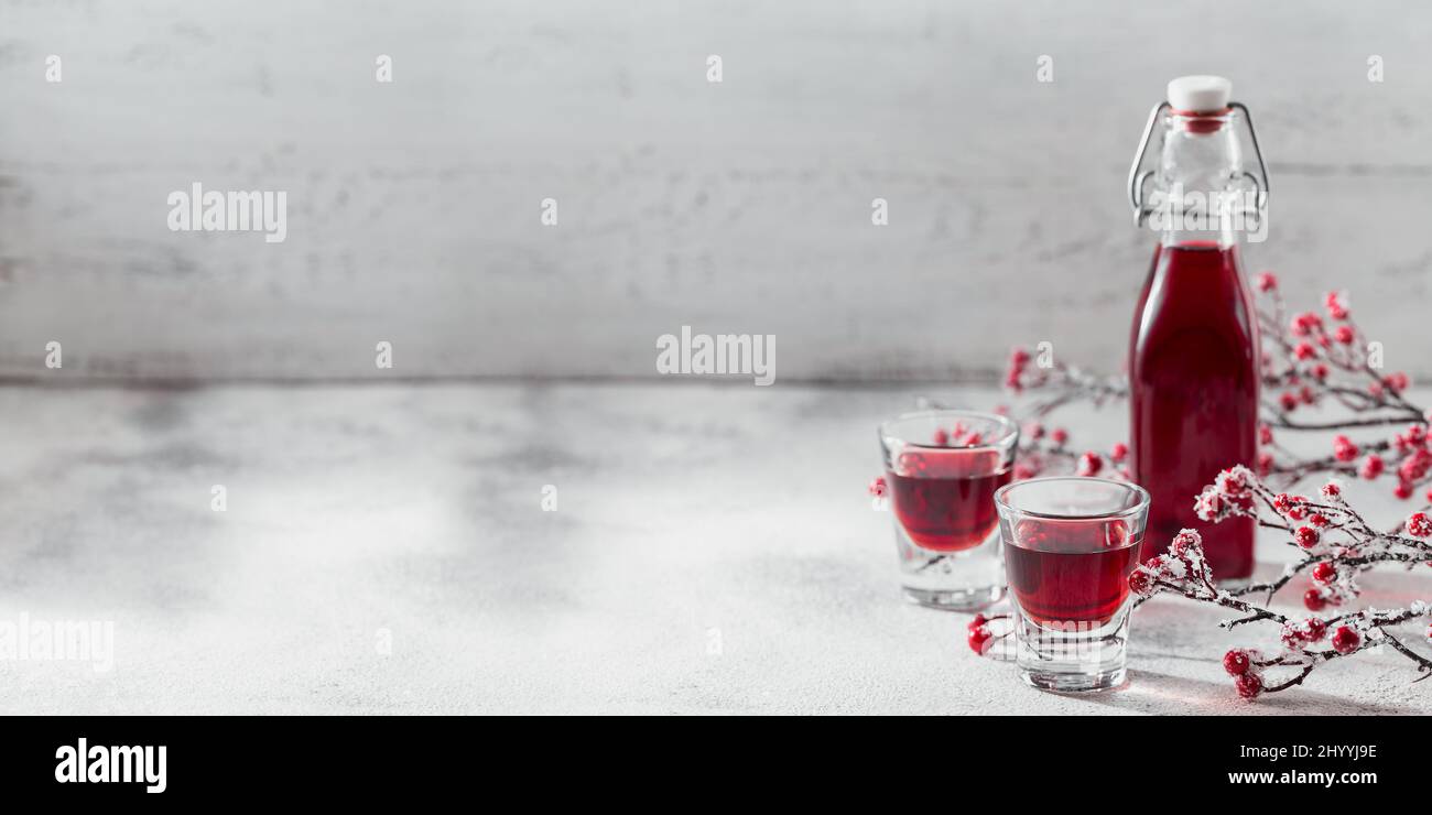 Zwei Gläser roten Cocktail, Wodka oder Likör auf hellem Hintergrund. Alkohol Shot Drink Konzept Stockfoto