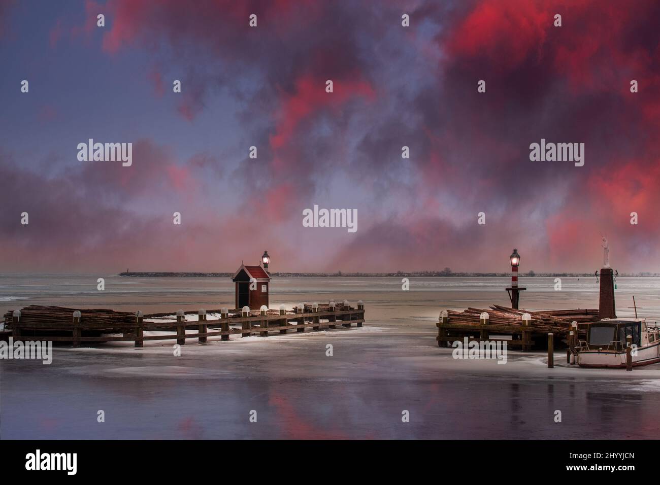 Landschaftskulisse des gefrorenen Hafens von Volendam bei Sonnenuntergang Stockfoto