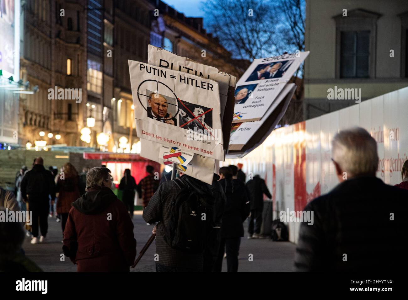 München, Deutschland. 15. März 2022. Schild mit der Lektüre: „ Putin = Hitler Lassen Sie sich die Geschichte nicht wiederholen“. Während die Coronavirus-Infektionen neue Höchststände erreichen, gehen die Menschen am 15. März 2022 in der Münchner Fußgängerzone einkaufen. (Foto: Alexander Pohl/Sipa USA) Quelle: SIPA USA/Alamy Live News Stockfoto