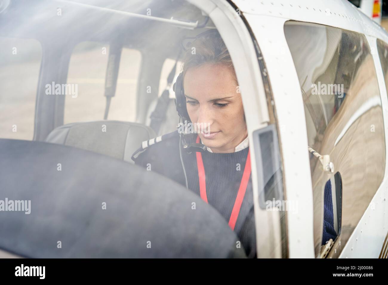 Vorderansicht von außen einer Pilotin im Cockpit eines Flugzeugs. Stockfoto