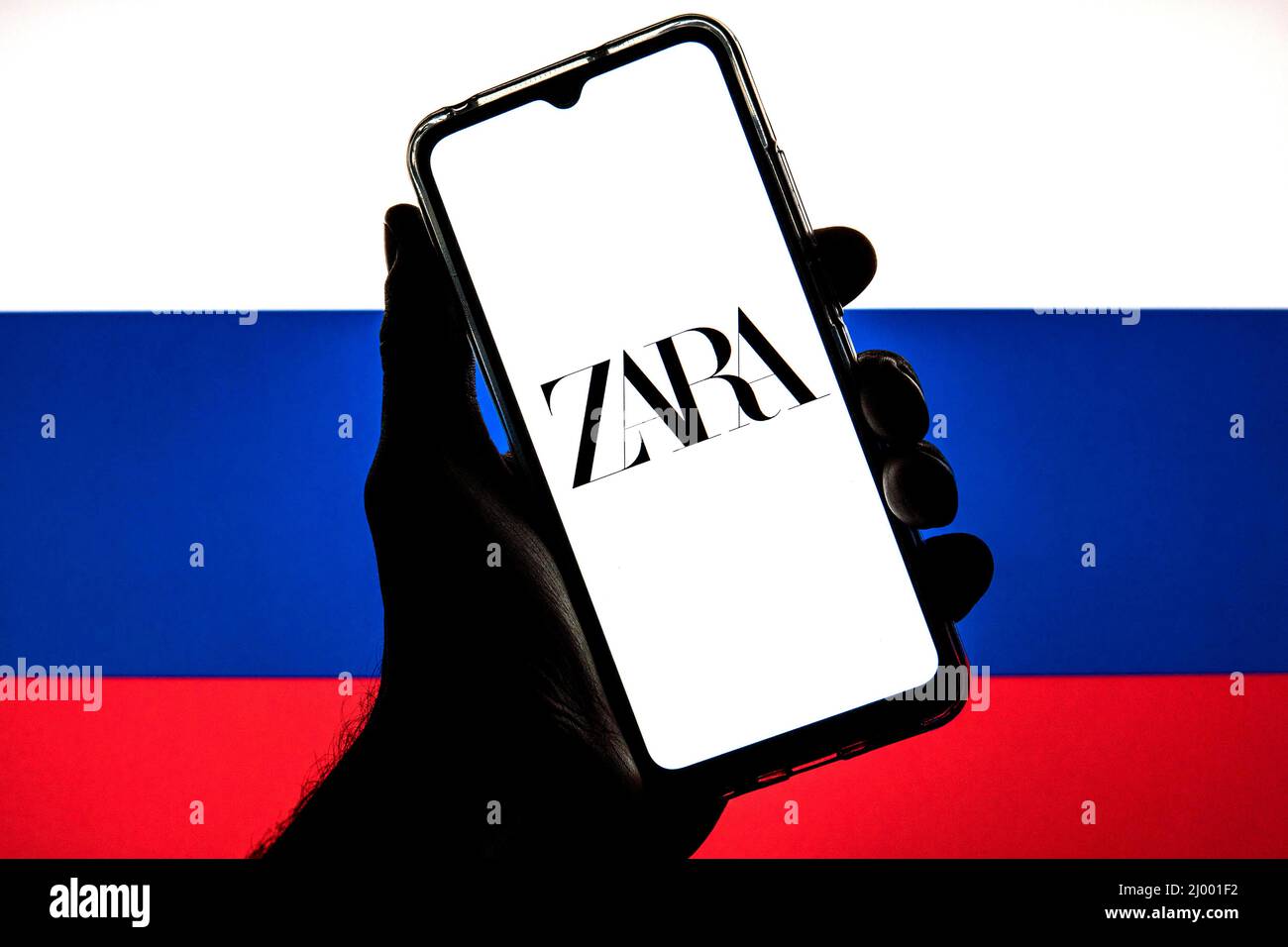 In dieser Abbildung ist ein Zara-Logo auf einem Smartphone mit einer Flagge der Russischen Föderation im Hintergrund zu sehen. Stockfoto