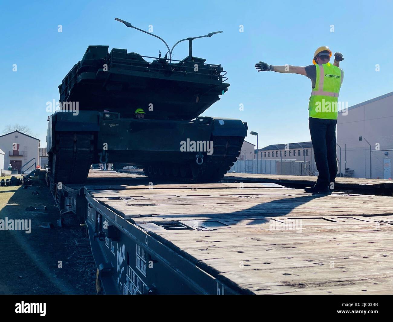 Mannheim, Deutschland. 14. März 2022. Ein Arbeiter hilft beim Laden eines Hauptkampfpanzers der US-Armee M1A2 Abrams auf einen deutschen Schienenwagen auf dem Coleman-Gelände am 14. März 2022 in Mannheim. Das US-Militär verlagern eine ganze Panzerbrigade aus vorpositionierten Beständen in das Trainingsgebiet Grafenwoehr, da die NATO nach der russischen Invasion in der Ukraine die Sicherheit erhöht. Quelle: Maj. Allan Laggui/U.S. Army/Alamy Live News Stockfoto