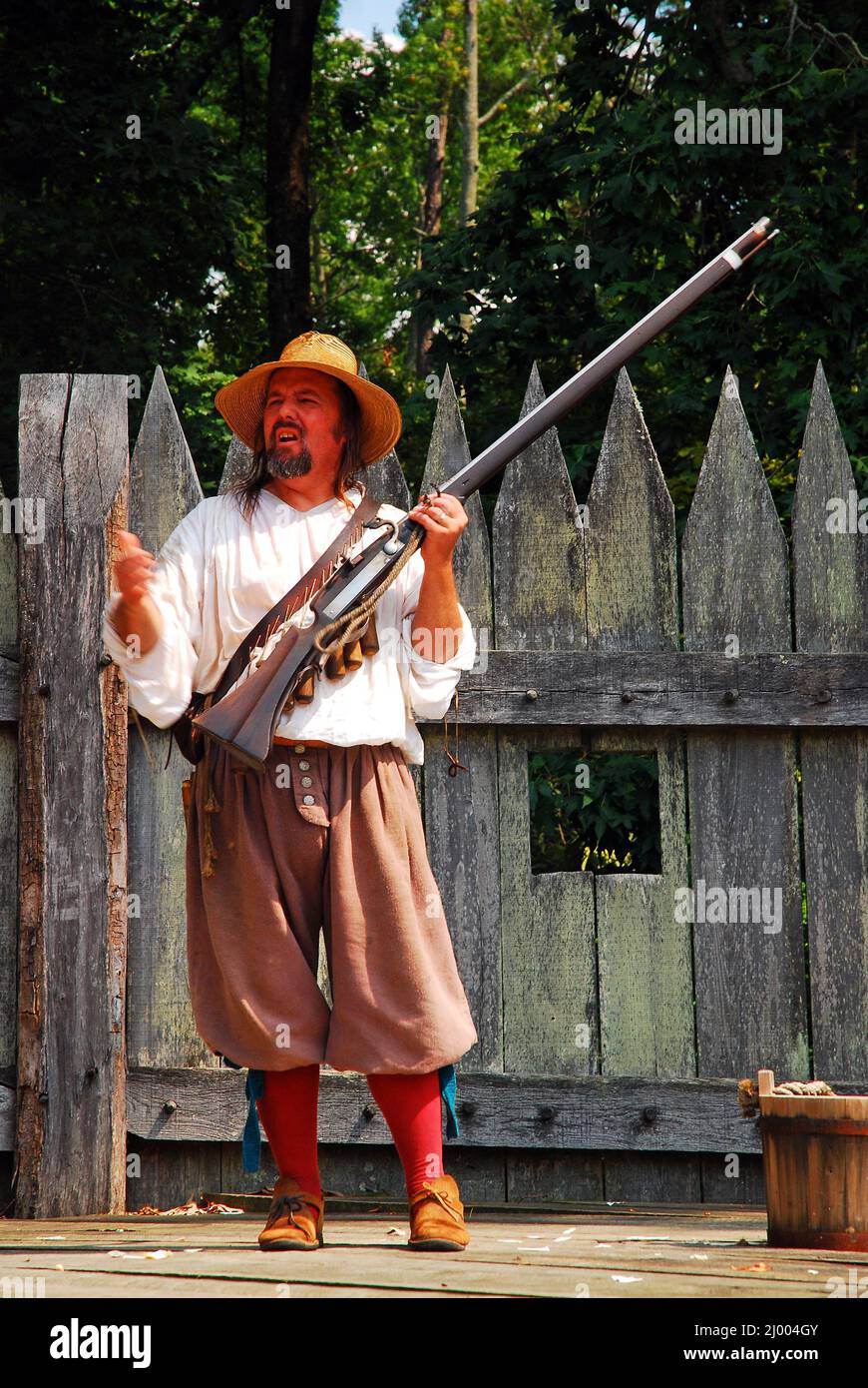 Ein kostümierter Re-enactor zeigt eine Kanone aus der Kolonialzeit in Jamestown, Virginia Stockfoto