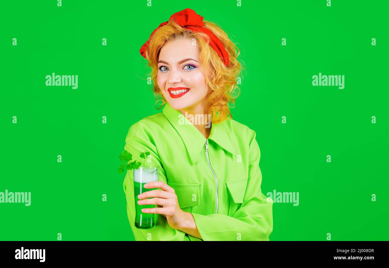 Frau trinkt Bier im Pub. St. Patricks Day. Lächelndes Mädchen mit Glas grünes Getränk mit Kleeblatt. Stockfoto