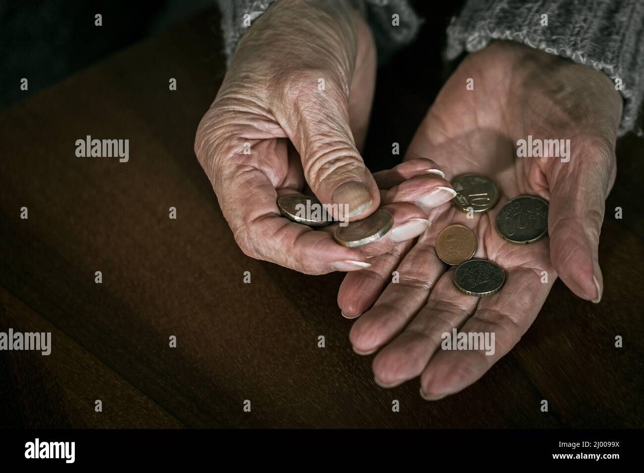 Nahaufnahme der Hände älterer Frauen mit Euromünzen. Rentnerin zählt Geld in ihre Hände Stockfoto