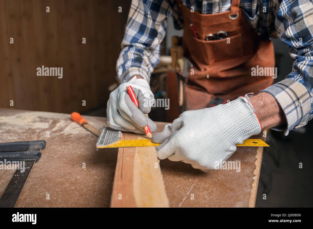 Konzept der Holzbearbeitung und Möbelherstellung. Der Zimmermann in der Werkstatt zeichnet die Details des Möbelschranks mit einer quadratischen, Nahaufnahme aus. Hochwertige Fotografie Stockfoto