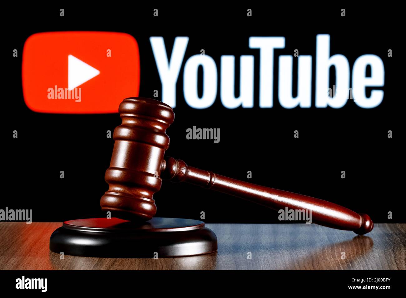 Gavel auf dem Tisch vor dem Hintergrund des Youtube-Logos. Das Konzept des Prozesses. Stockfoto
