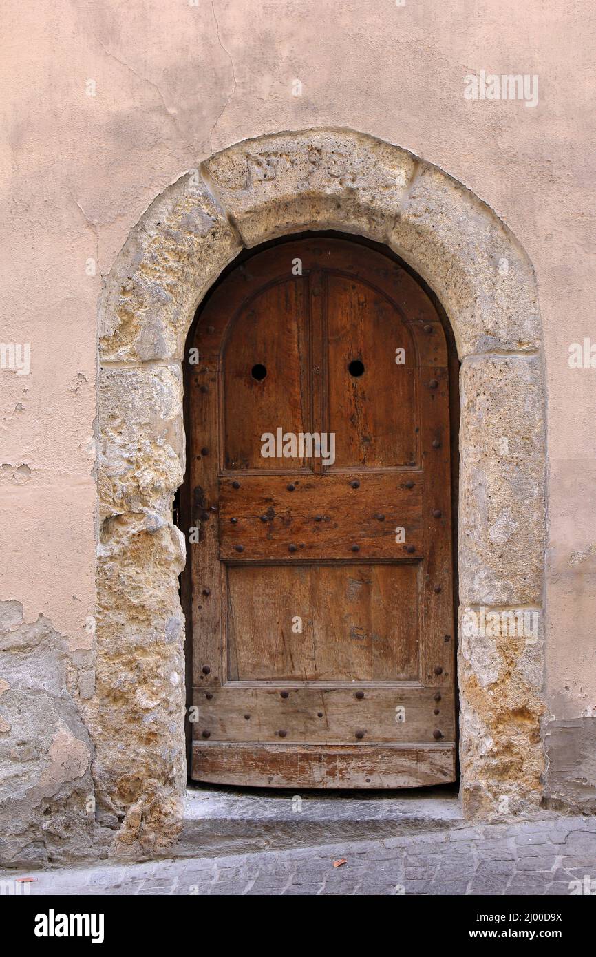 Alte Tür mit erodiertem Steinbogen in der Stadt Sion, Schweiz Stockfoto