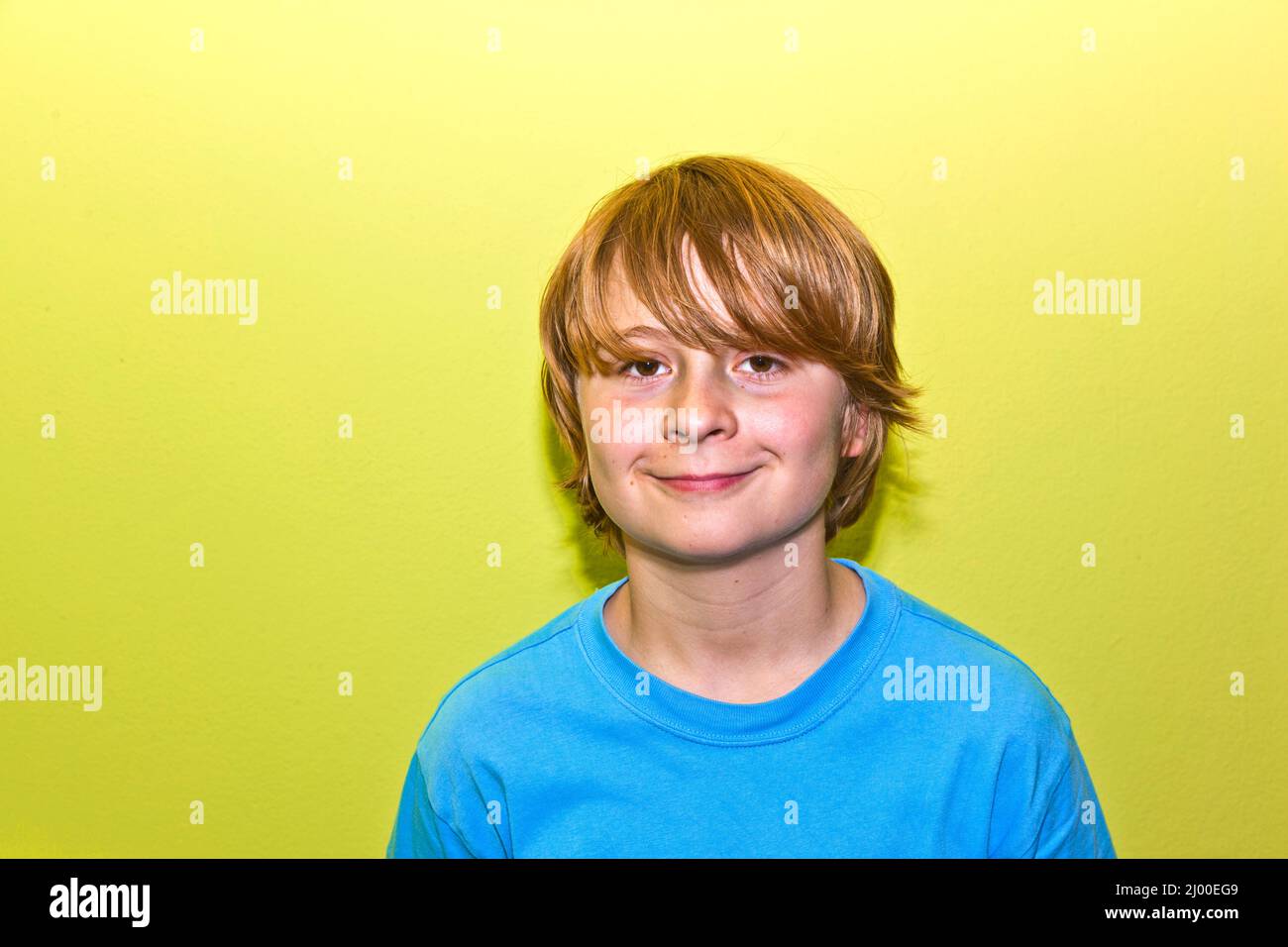 glücklich lächelnde junge mit gelben Wand Stockfoto