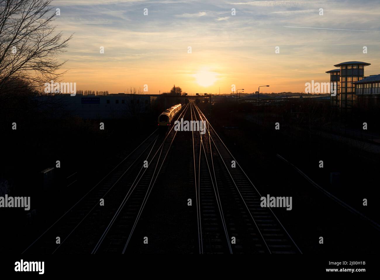 East Midlands Züge der Klasse 222 Merdian Train 222018 auf der midland-Hauptlinie in Nottingham mit Zug und Schienen, die in der untergehenden Sonne glitzern Stockfoto
