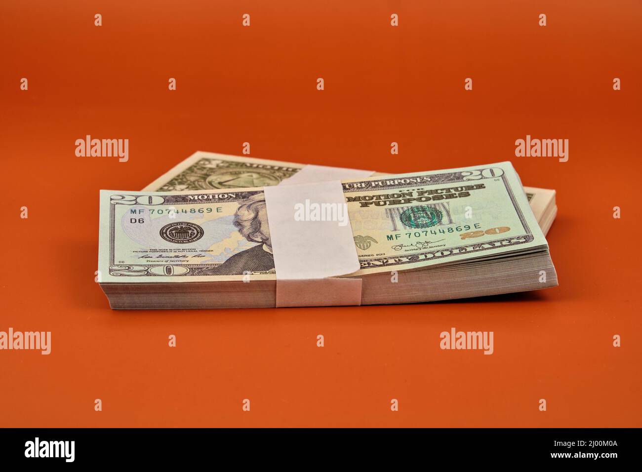 Bundles von Dollarscheinen auf einem Tisch mit einer orangen Farbe. Stockfoto