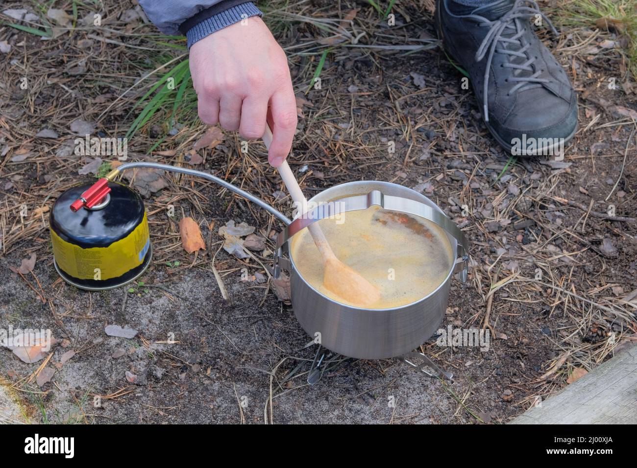 Suppe im Topf im wilden Wald. Camping Lebensmittelherstellung. Essen für Reisende für Outdoor-Aktivitäten. Stockfoto