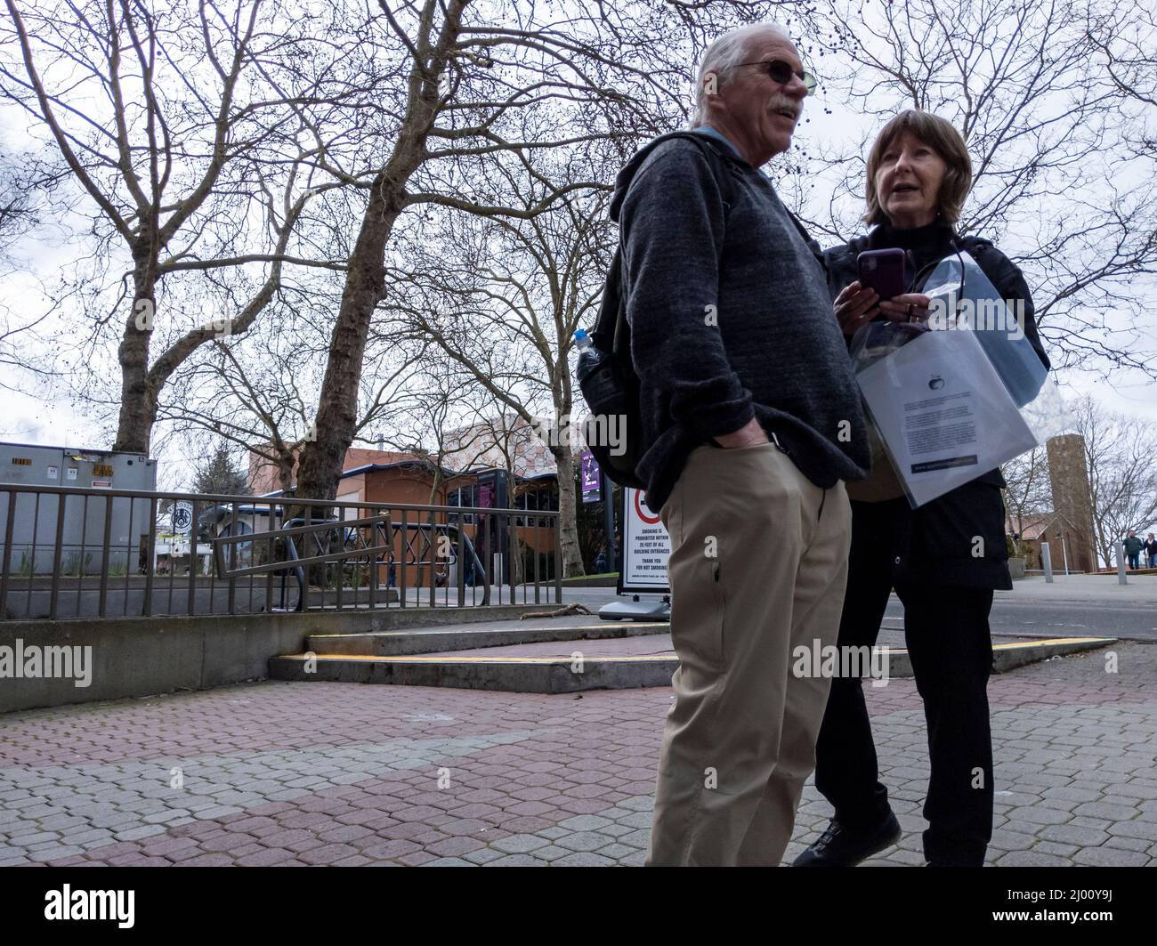 Seattle, WA USA - ca. März 2022: Ältere Männer und Frauen, die an einem bewölkten Tag nach Wegbeschreibungen fragen, während sie die Innenstadt von Seattle genießen. Stockfoto