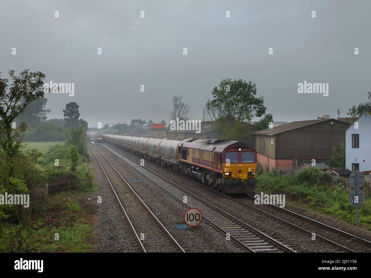 DB Cargo Rail UK-Lokomotive der Baureihe 66 66183, die Ashchurch nach Tewkesbury mit einem Güterzug leerer Castle-Zementtanks passiert Stockfoto