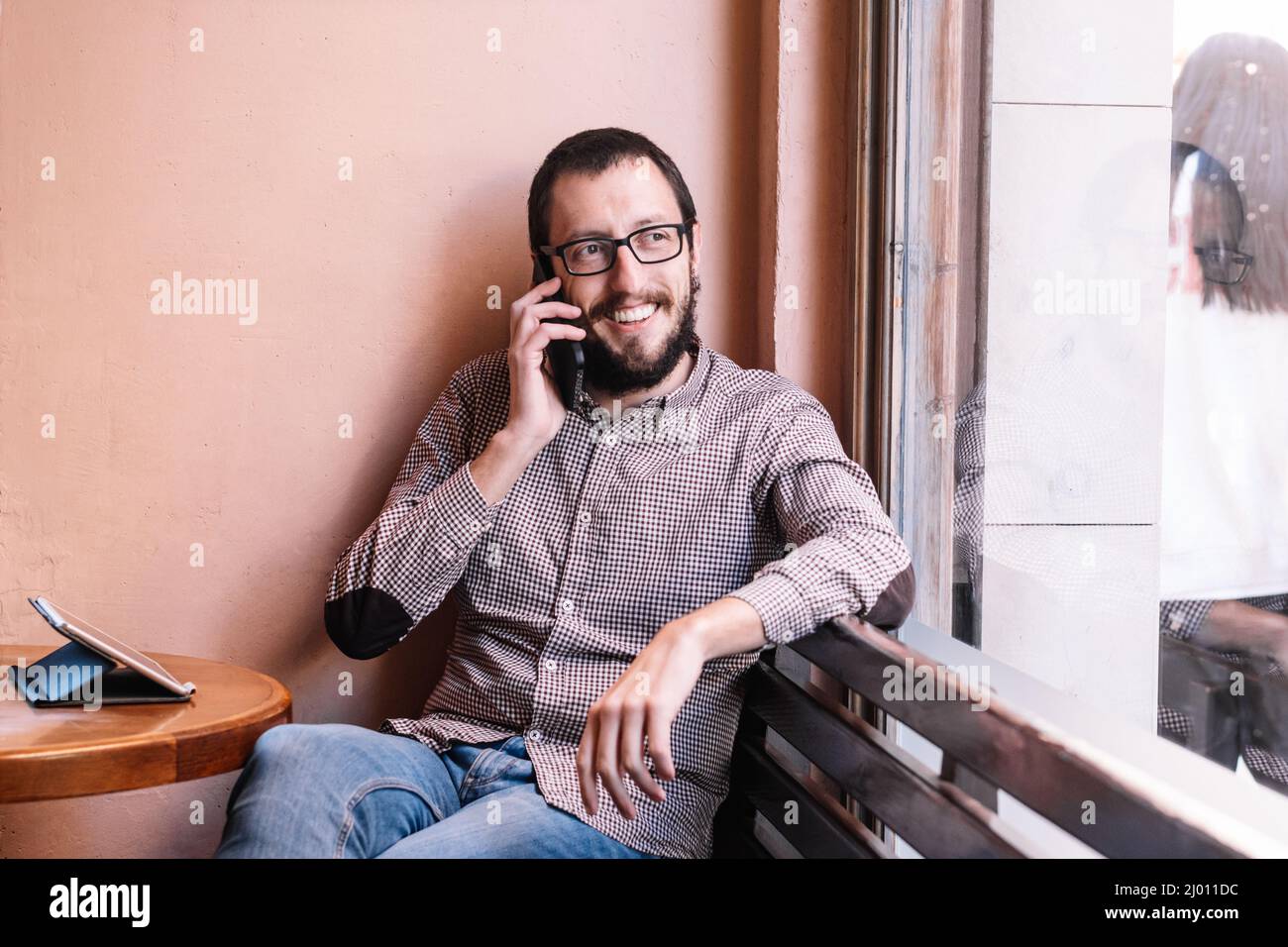 Junger kaukasischer Mann lächelt glücklich im Gespräch auf dem Smartphone Stockfoto