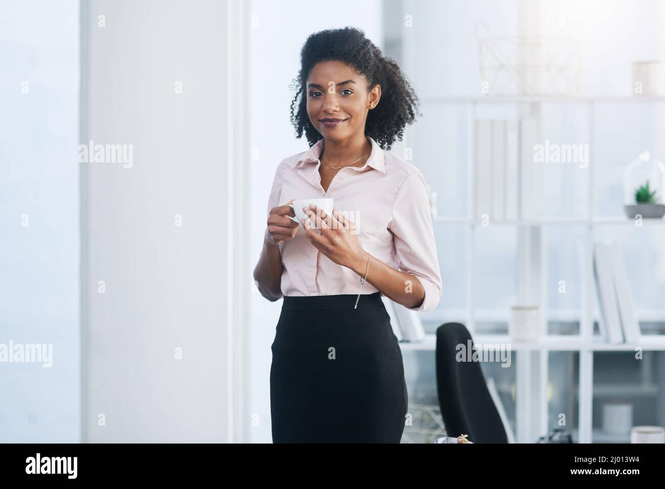 Machen Sie eine kurze Pause, bevor Sie zur Arbeit zurückkehren. Porträt einer jungen Geschäftsfrau, die in einem Büro eine Tasse Kaffee trinkt. Stockfoto
