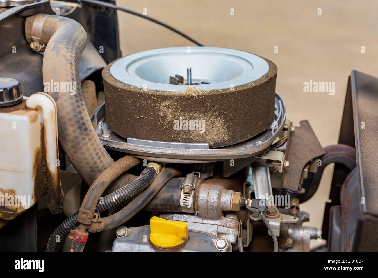 Verschmutzter Luftfilter am Traktor des Rasenmähers. Reparatur-, Wartungs- und Tune-Up-Konzept für kleine Motoren Stockfoto