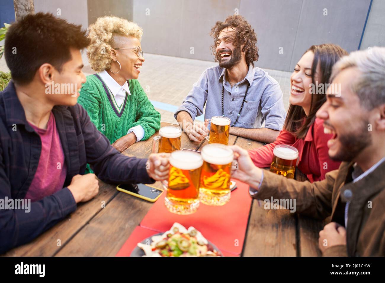 Glückliche Freunde, die Spaß im Freien haben. Junge Menschen genießen Zeit zusammen draußen, Jugend Freundschaft Konzept. Hände toasten Bier. Stockfoto