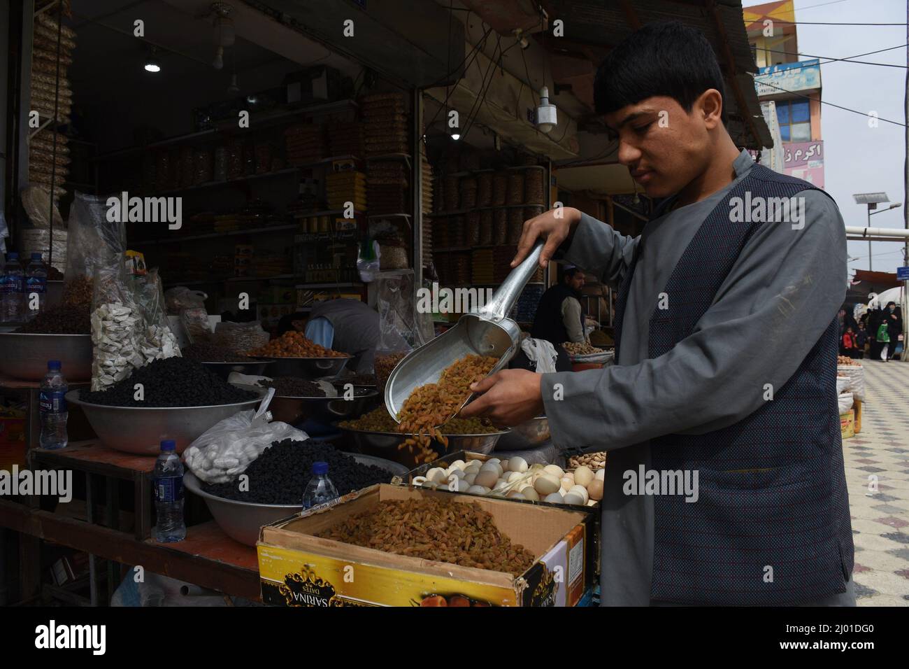 Mazar i Sharif, Afghanistan. 15. März 2022. Ein Mann bereitet am 14. März 2022 auf einem Markt in Mazar-i-Sharif, der Hauptstadt der Provinz Balkh, Afghanistan, Trockenfrüchte zu. Die Afghanen bereiten sich in diesen Tagen auf das bevorstehende Nawroz-Festival vor. Kredit: Kawa Basharat/Xinhua/Alamy Live Nachrichten Stockfoto