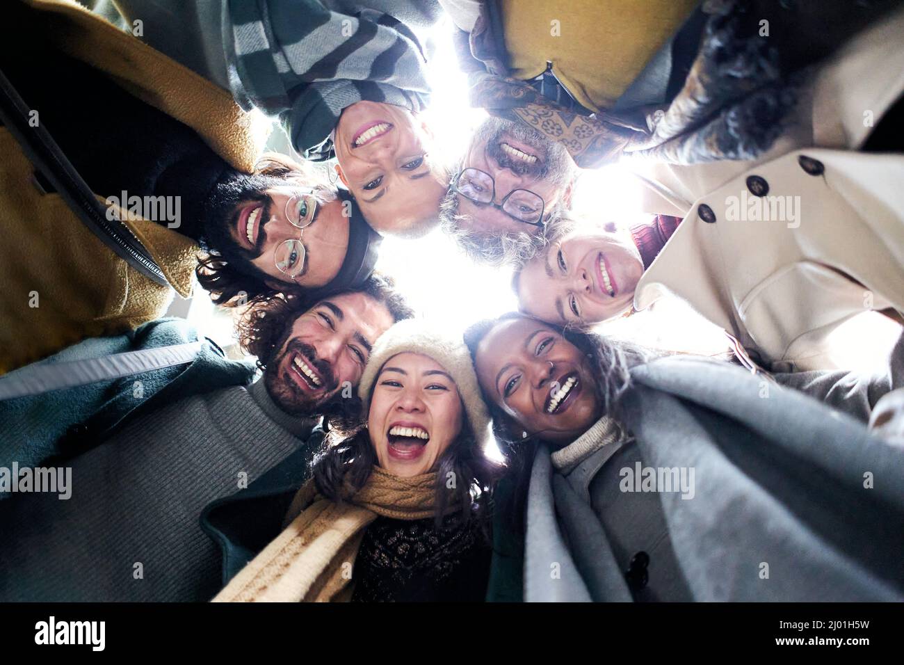 Niedriger Winkel Kreis einer fröhlichen vielfältigen Gruppe von Menschen verschiedener Rassen ein Alter Blick auf die Kamera glücklich zusammen Spaß haben Stockfoto