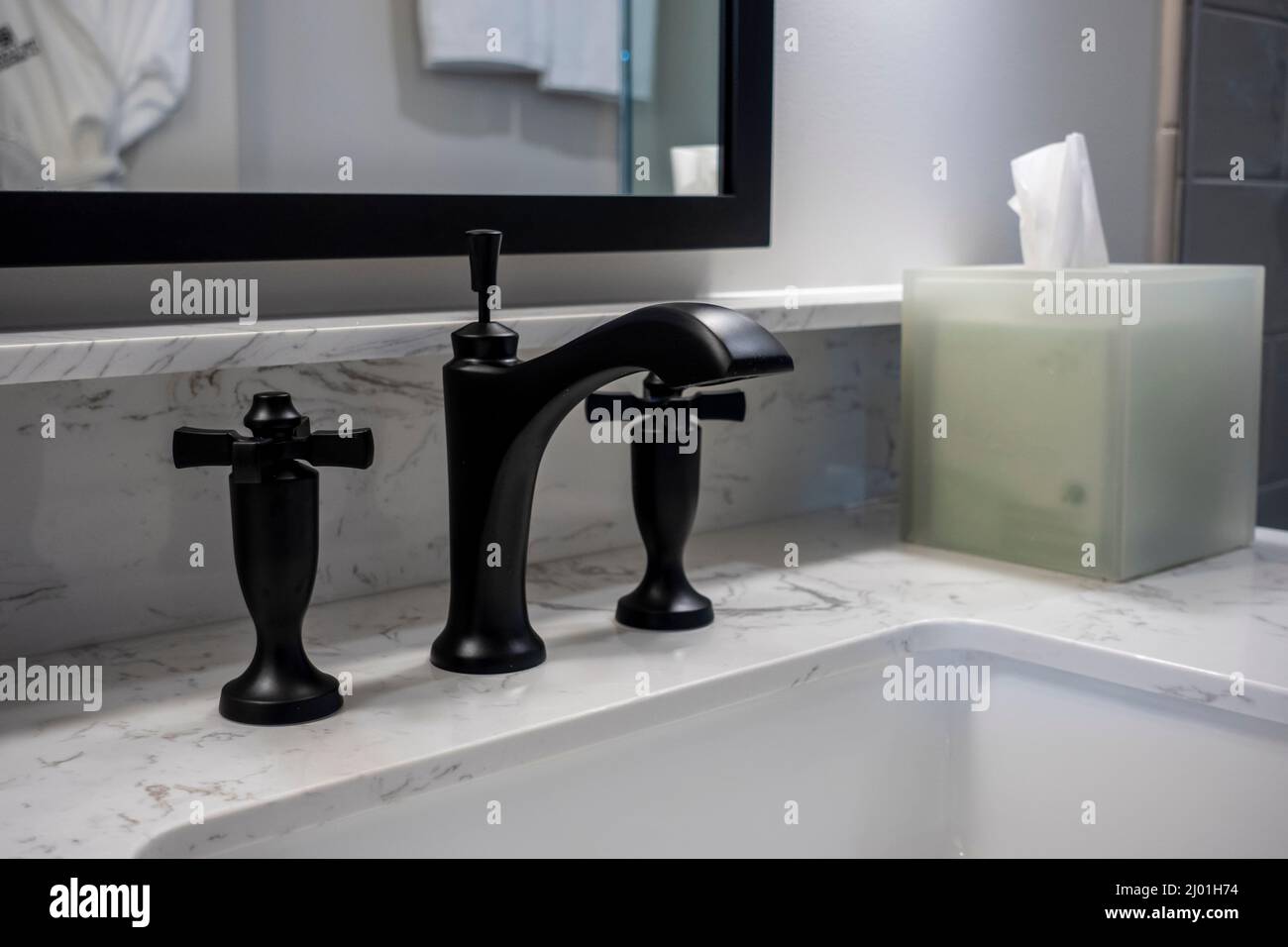 Angewinkelter, selektiver Fokus auf einen modernen schwarzen Wasserhahn im Badezimmer in einem luxuriösen Hotel Stockfoto