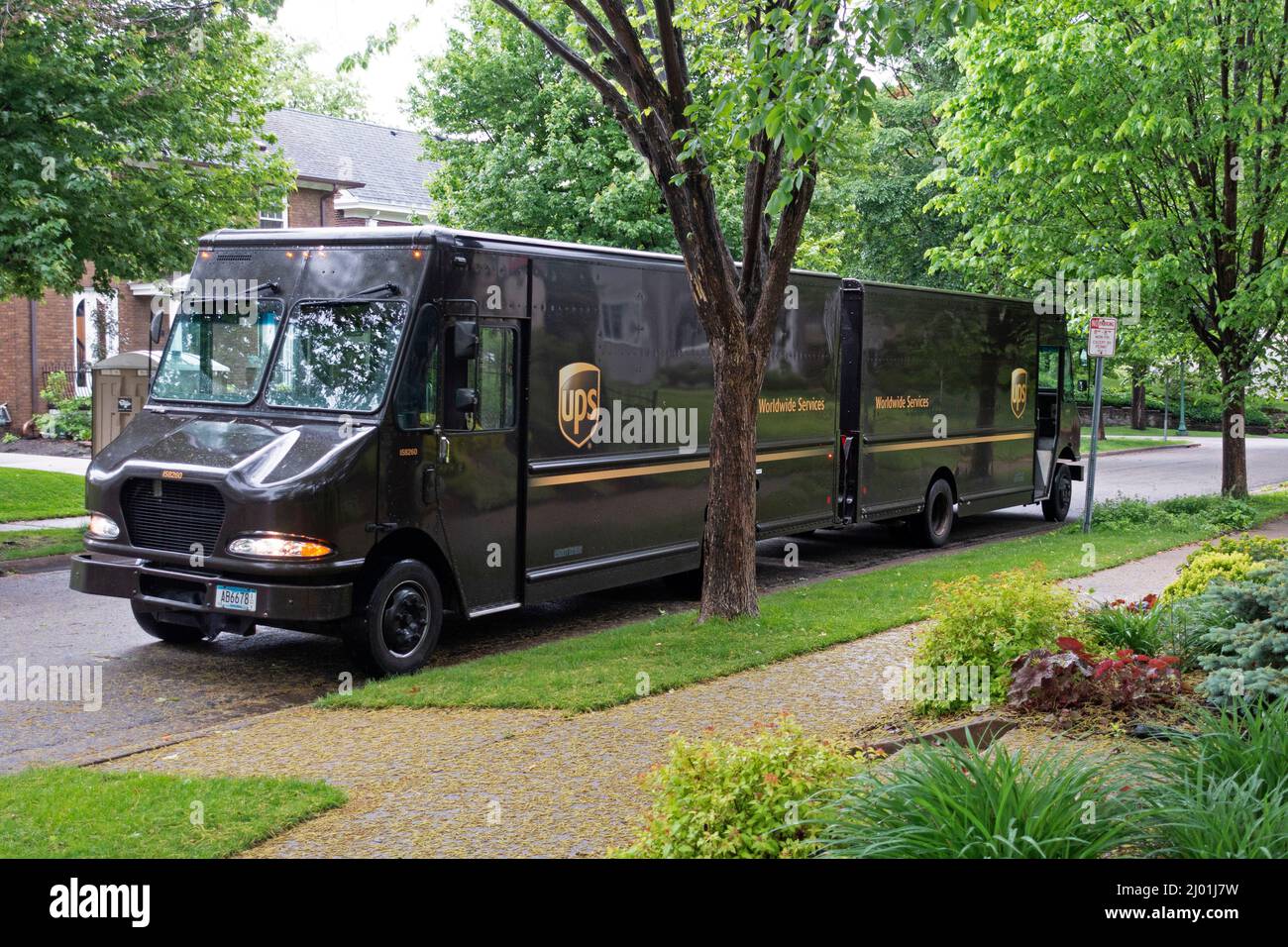 Es sind immer wieder doppelte UPS-Lastwagen geparkt, die Pakete in der Nachbarschaft liefern. St. Paul Minnesota, USA Stockfoto