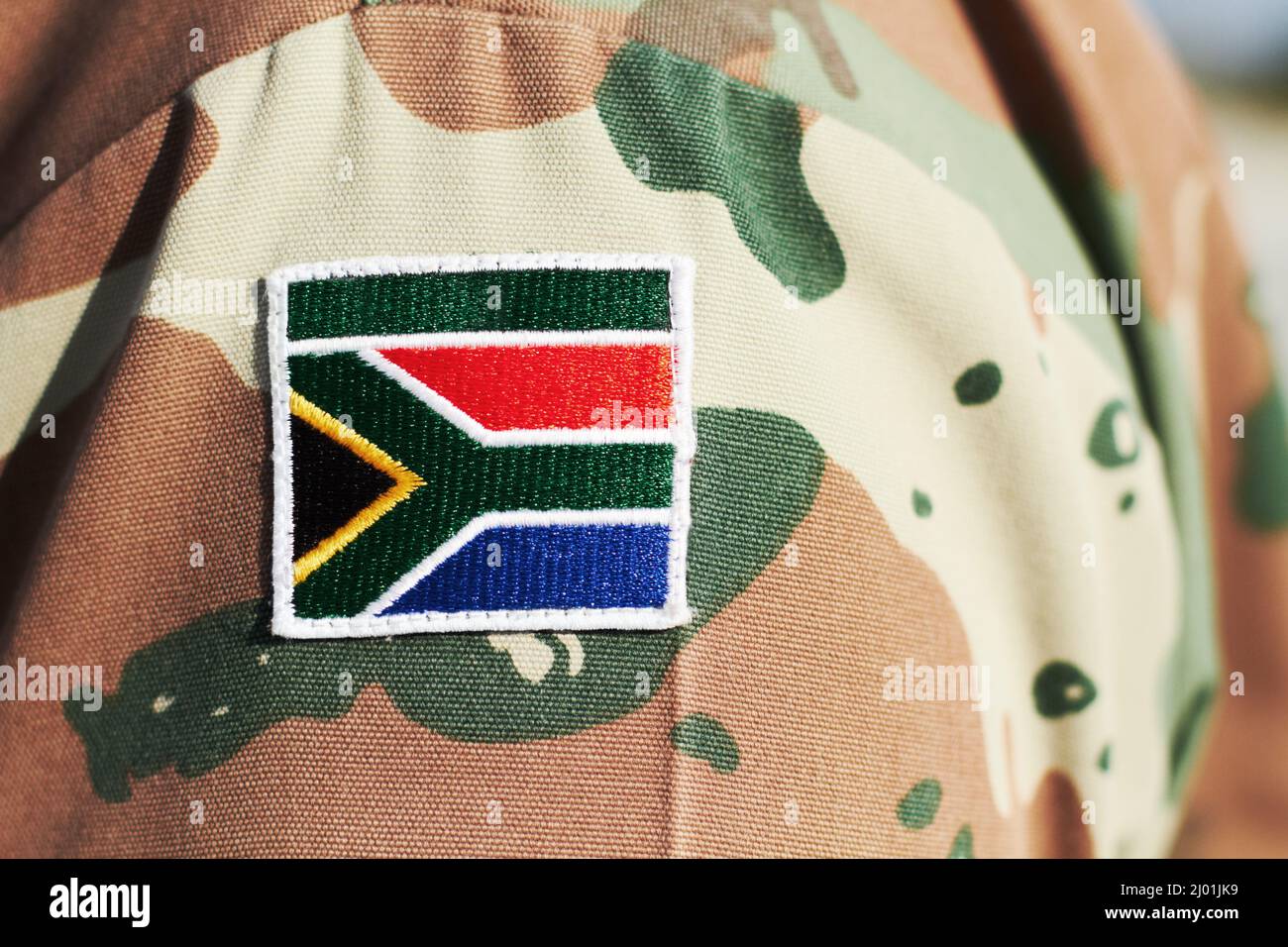 Stolzer Kampfmann. Nahaufnahme einer südafrikanischen Flagge auf einer Soldatenuniform. Stockfoto