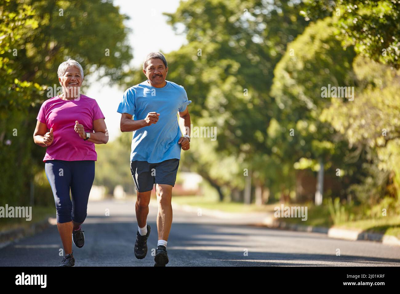 Glück und Gesundheit sind unser Ziel. Aufnahme eines reifen Paares, das an einem sonnigen Tag zusammen joggt. Stockfoto