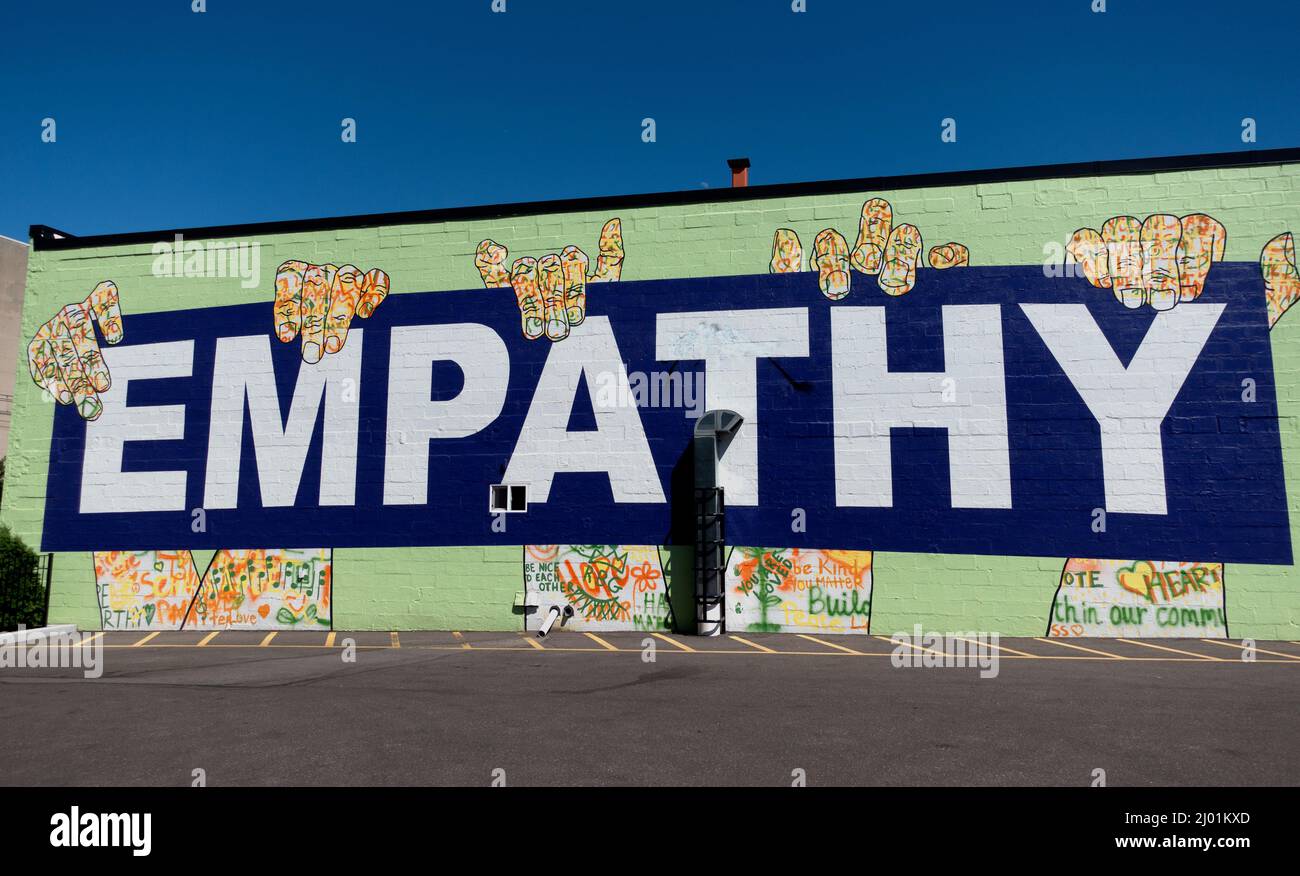 Großes bedrucktes Empathie-Zeichen, das von gemalten Händen an einer Wand eines Gebäudes gehalten wird. St. Paul Minnesota, USA Stockfoto