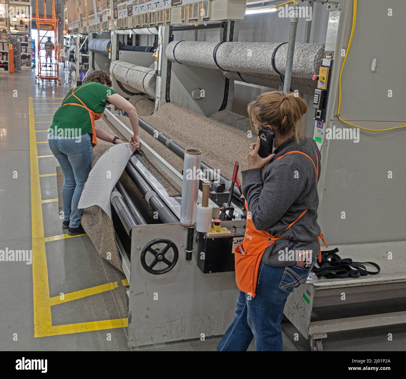 Der Teppich wird mit einer Schneidevorrichtung geschnitten, da die automatische Schneidevorrichtung nicht funktioniert. Fergus Falls, Minnesota, USA Stockfoto