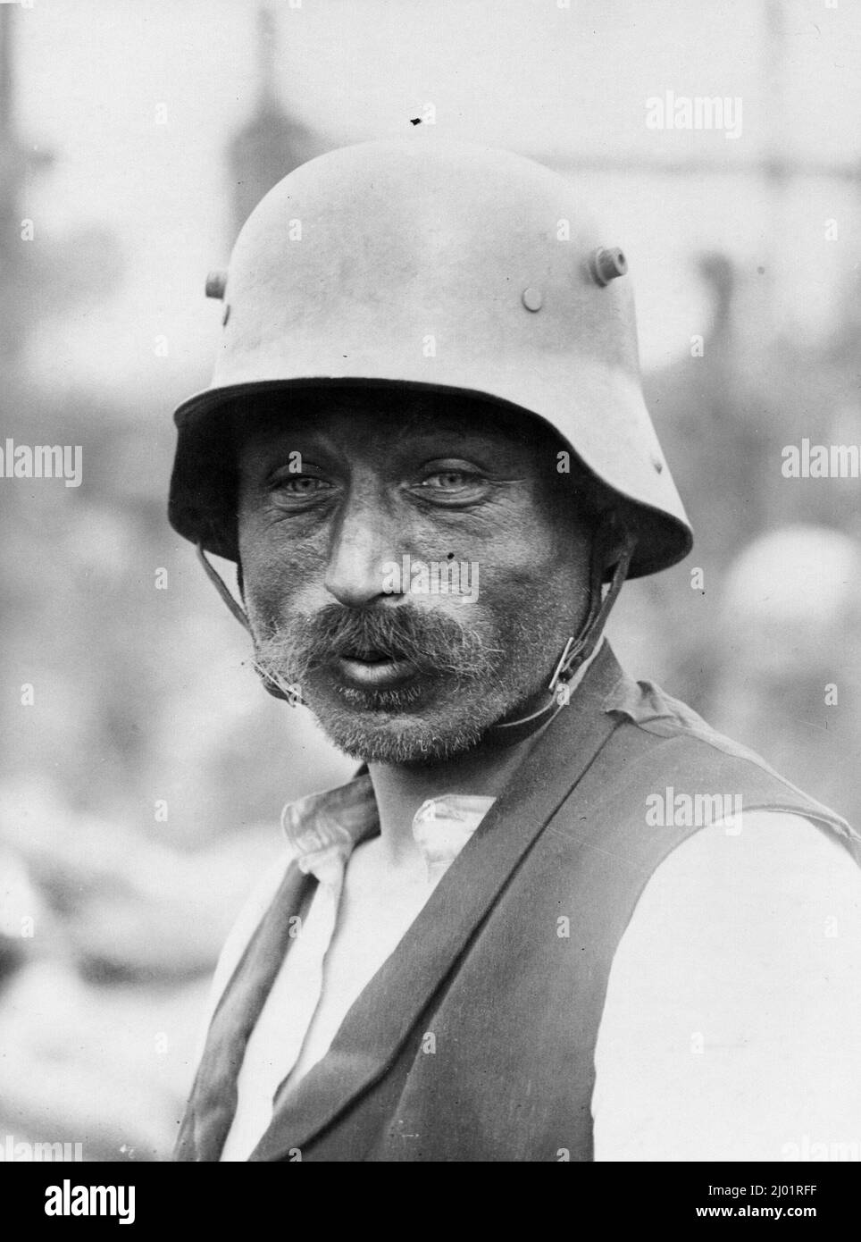 Porträt eines deutschen Gefangenen aus dem Jahr WW1, der einen Helm und, was sein könnte, Zivilkleidung trägt. Stockfoto