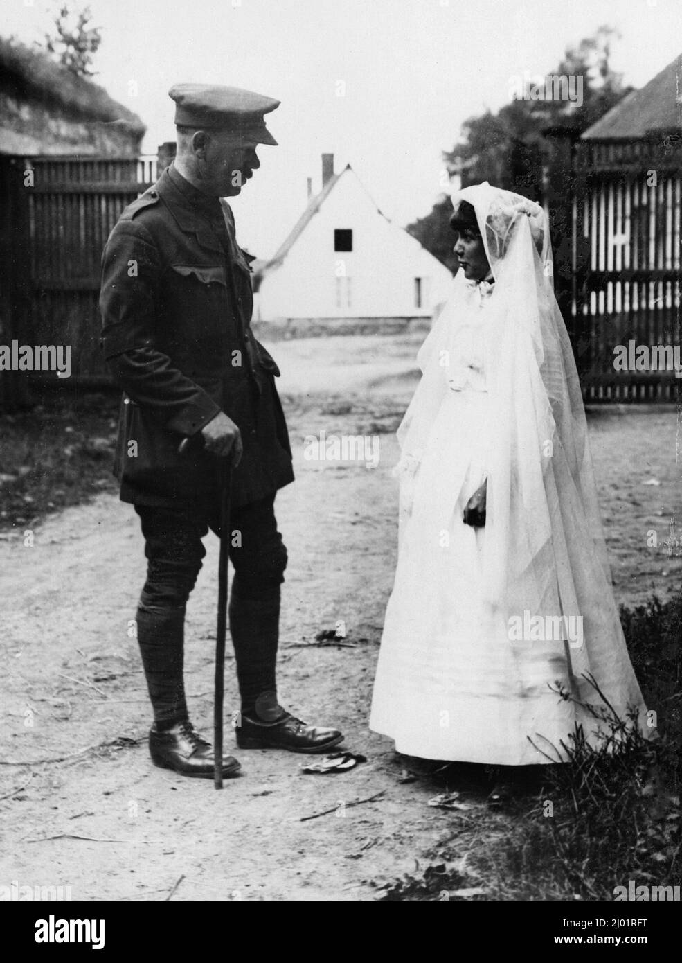 Ein Offizier der britischen Armee spricht über ein kleines französisches Mädchen, das WW1 an der Westfront zu ihrer ersten Messe geht Stockfoto