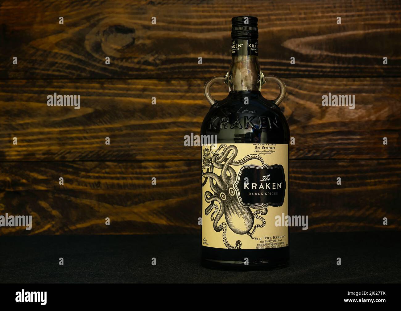 Flasche englischer Kraken Black Spiced Rum auf dunklem Holzhintergrund. Schwarzer karibischer Rum Kraken im Alter von 1-2 Jahren, gemischt mit einer Mischung aus 11 Gewürzen. Rus Stockfoto