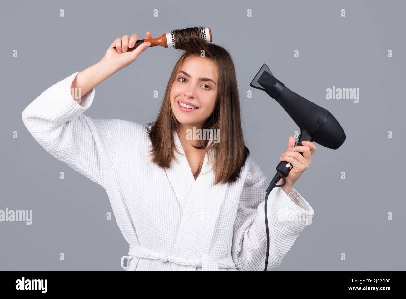 Frau kämmt Haare. Porträt des weiblichen Modells mit einem Kamm Bürsten  Haar und Trockner Haar mit Haartrockner. Mädchen mit Fön und Haarbürste,  Haarpflege und Stockfotografie - Alamy