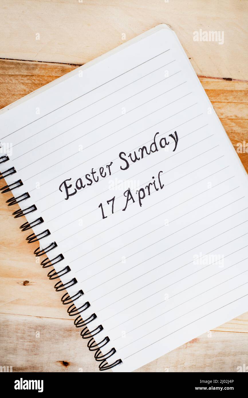 Ostersonntag 17. April handgeschrieben auf einem Notizbuch mit rustikalem Hintergrund Stockfoto