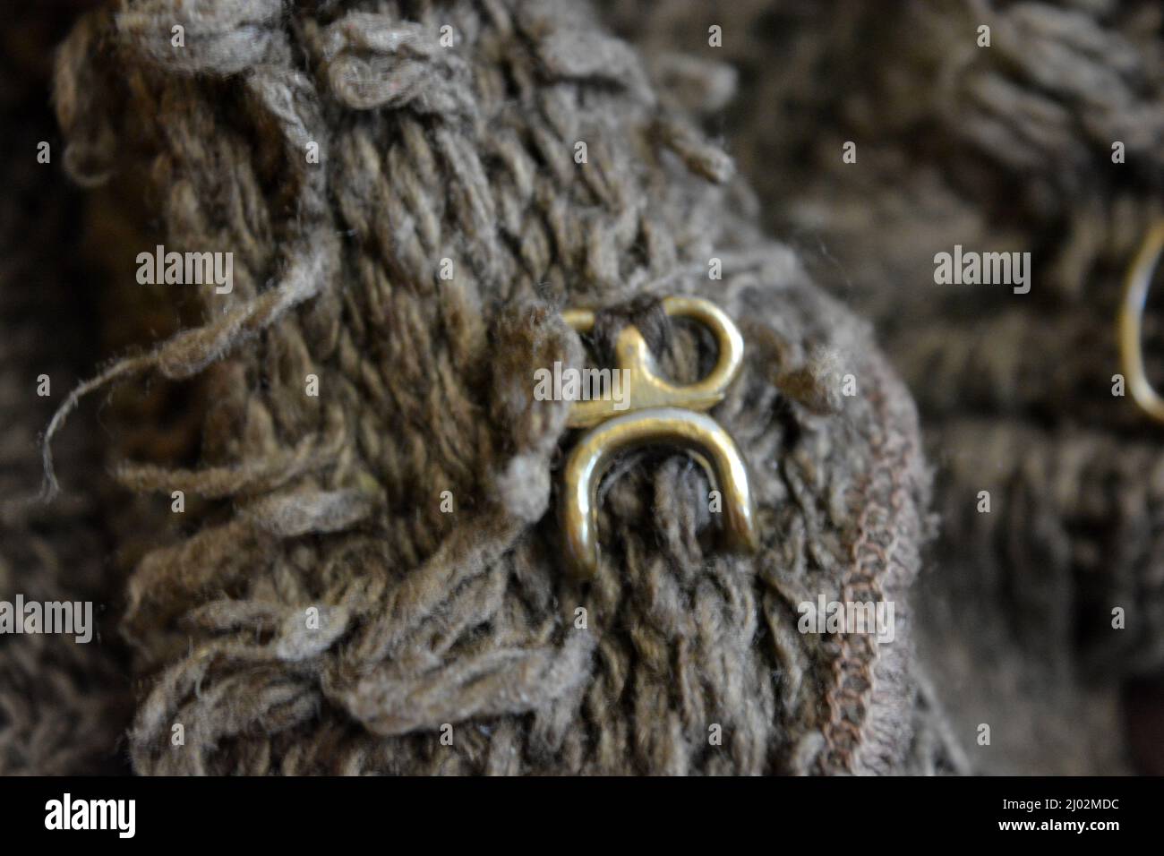 Damenbekleidung, stylische Strickwaren aus Braun, Oliv, Dunkelbeige, Naturwolle, dichten Garnen und dunkelgoldenen Haken, Riegel. Stockfoto