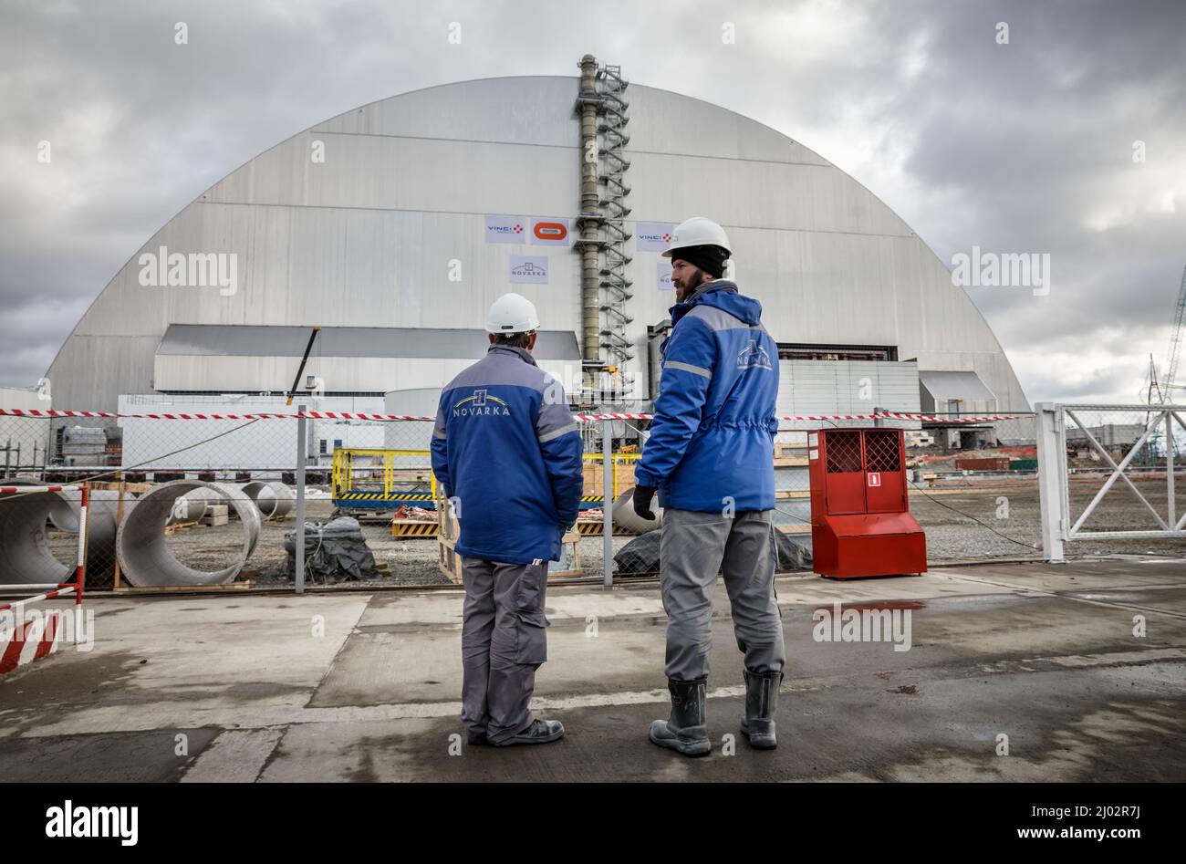 Tschernobyl, Ukraine. 28.. November 2016. Zwei Arbeiter stehen vor dem Entsperrbogen des 