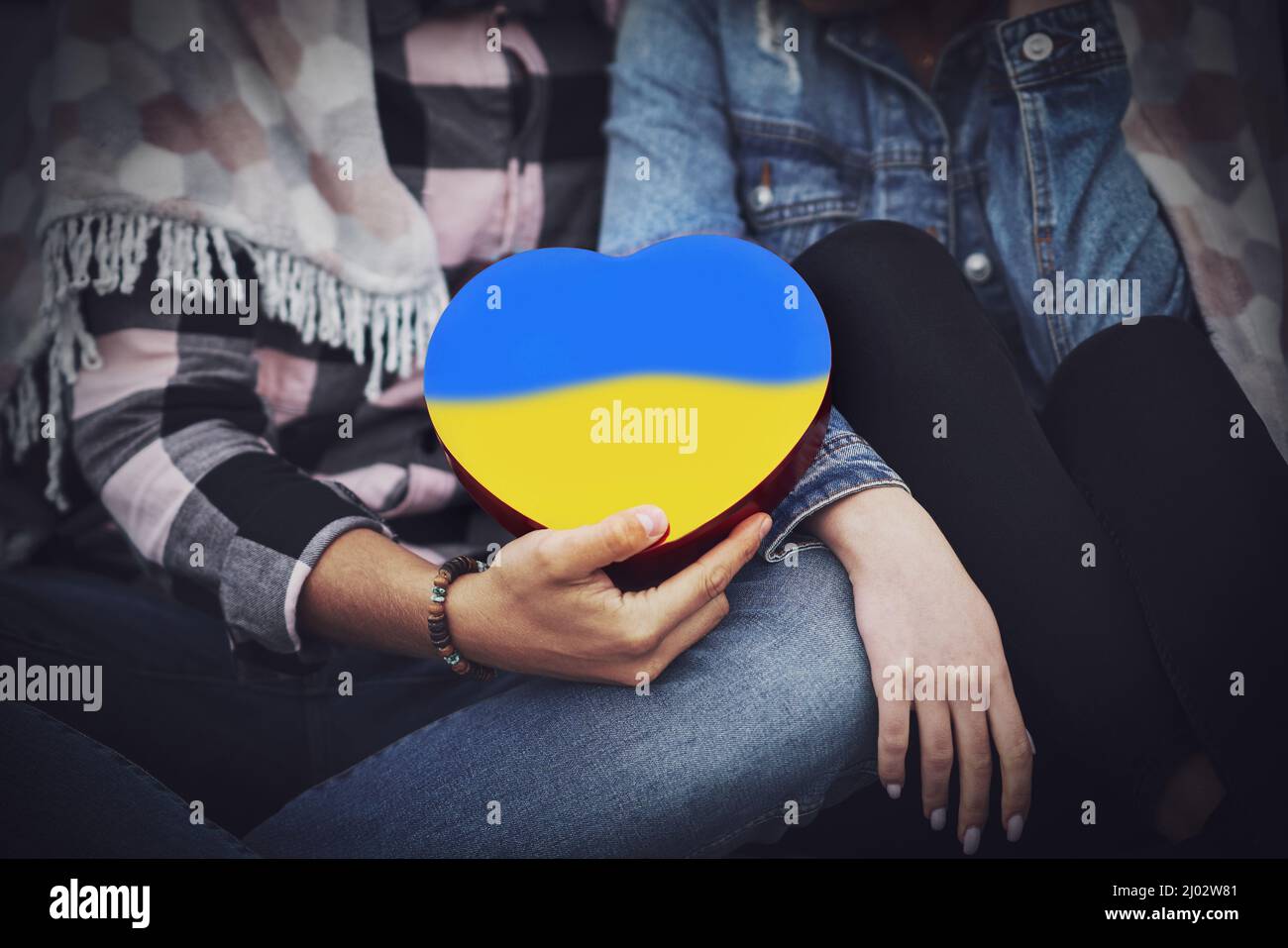 Familie Hände halten ein Herz in ukrainischen Farben Stockfoto