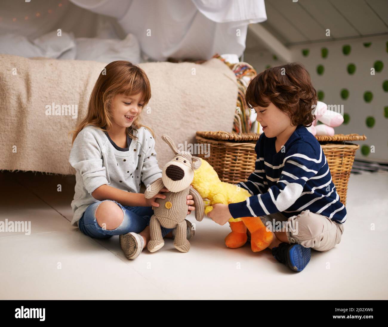 Lasst uns unseren eigenen Streichelzoo machen. Aufnahme von zwei liebenswerten Geschwistern, die mit ihren Stofftieren spielen. Stockfoto