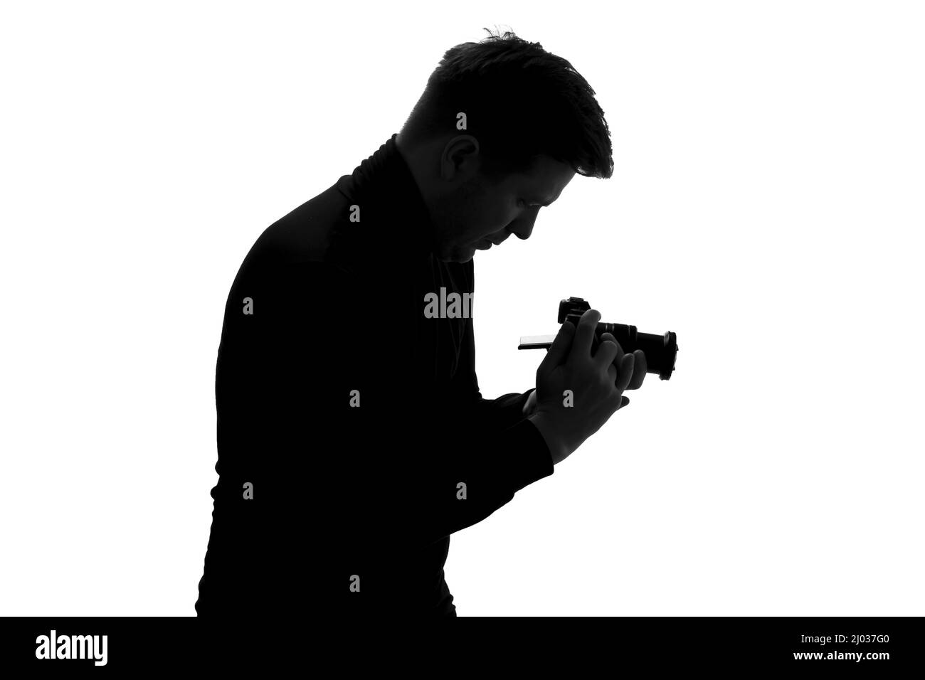 Junger Kaukasischer macht Foto. Silhouette in Studioaufnahmen Stockfoto