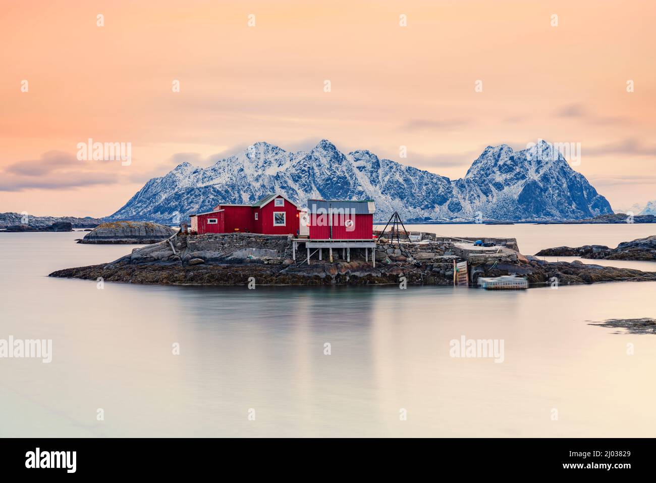 Isolierte rote Fischerhütten auf Felsen im kalten Meer bei Sonnenuntergang, Svolvaer, Nordland County, Lofoten Islands, Norwegen, Skandinavien, Europa Stockfoto