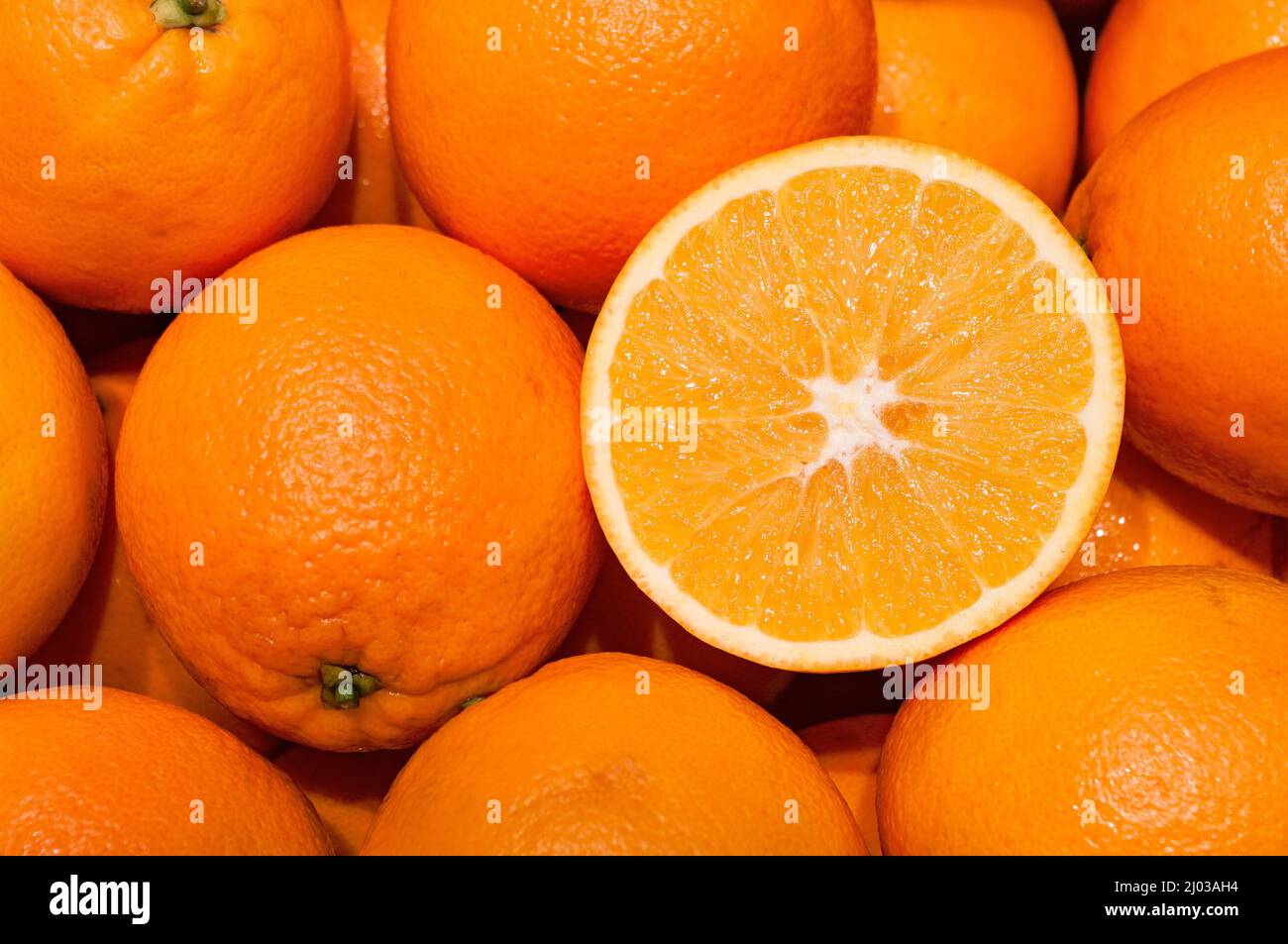 Die Orangen in einem Stapel anderer schneiden Stockfoto