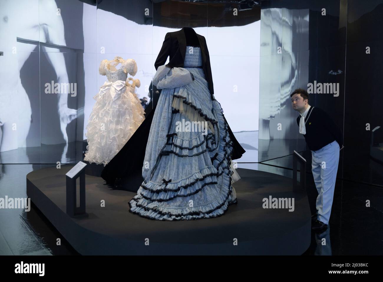 V & A Ausstellung Maskulinitäten gestalten:The Art of Menswear, ein Mann, der sich das Kleid von Harry Styles ansah, das von Alessandro Michele für Gucci entworfen wurde. Stockfoto