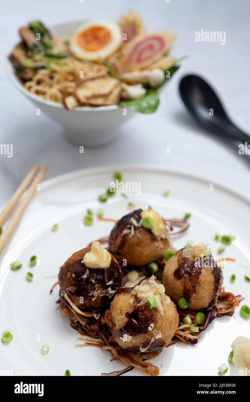 Eine Schüssel mit Ramen-Suppe und ein Teller Takoyaki-Snack Stockfoto